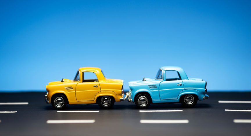 toy-cars-staged-in-a-rear-end-collision-on-a-blue-background